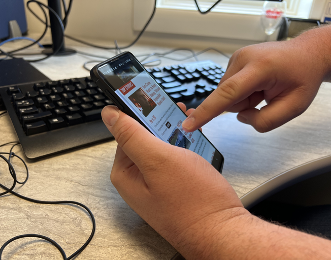 A person scrolling on their phone with their finger