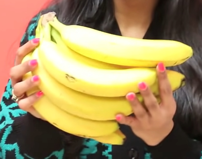 A woman holding a bunch of bananas