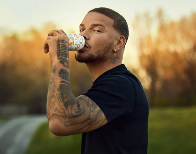 Kane Brown drinking a can of Olipop