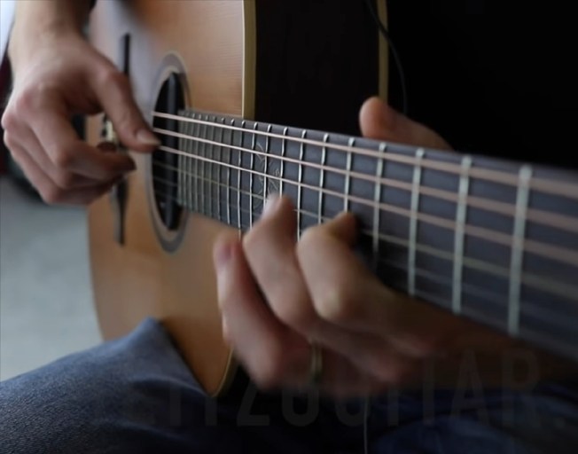 Person playing an acoustic guitar